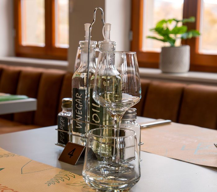 Ocat i ulje, papar i 2 prazne čaše na stolu restorana